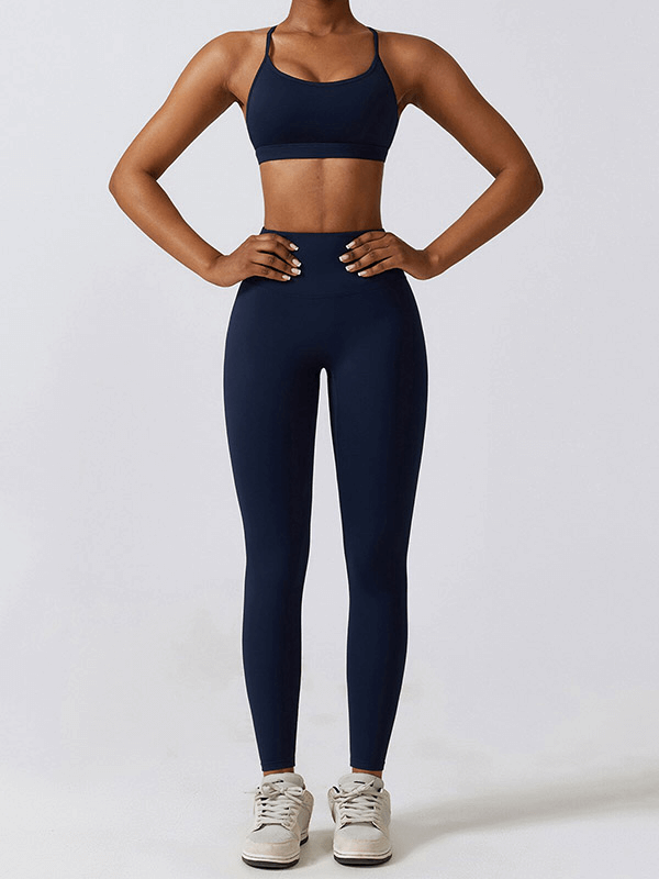 Woman wearing navy sportswear yoga set with leggings and sports bra, designed for fitness activities, featuring quick-dry fabric.