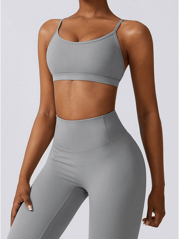Woman wearing gray sportswear yoga set, featuring a breathable nylon and spandex fabric. Ideal for running, fitness, and more.
