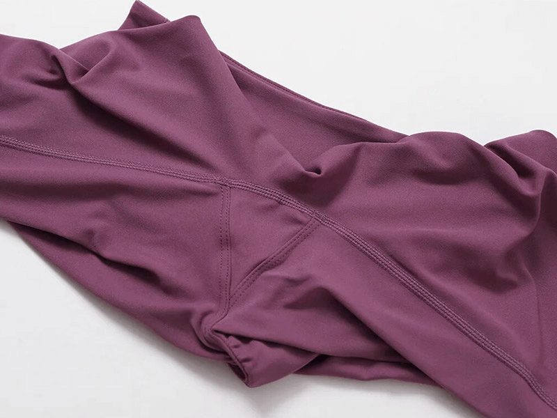 Close-up of purple Sportswear Yoga Set fabric showing stitching and breathable material for women's activewear.