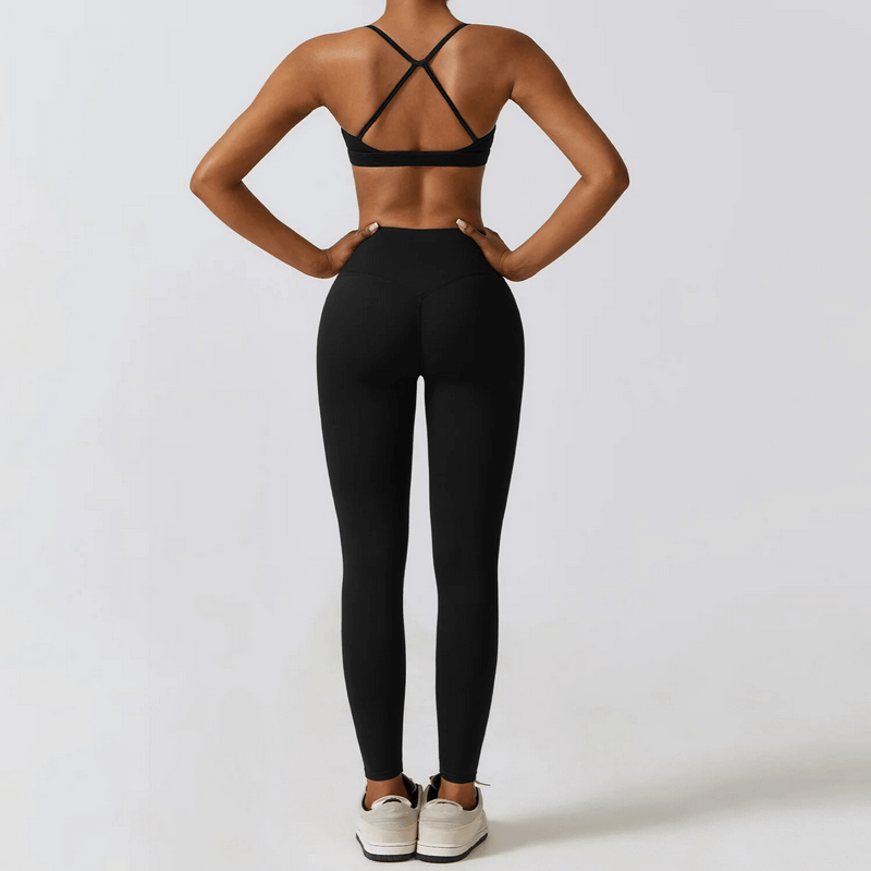 Woman wearing black sportswear yoga set, showcasing breathable and quick-dry features, ideal for fitness and outdoor activities.