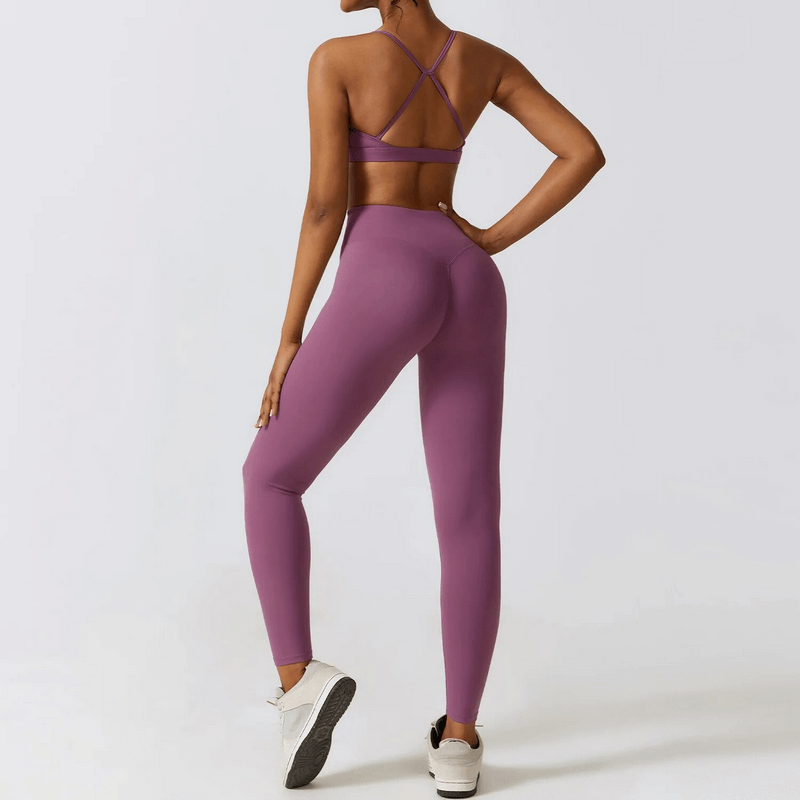 Woman modeling a purple yoga set with criss-cross back design, perfect for running, fitness, and outdoor sports. Ideal for women's activewear.