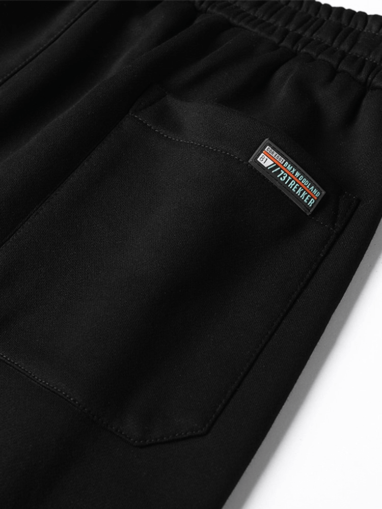Close-up of black joggers with side pocket detail, featuring drawstring waist. Sporty and casual style for men. Model SF1427.