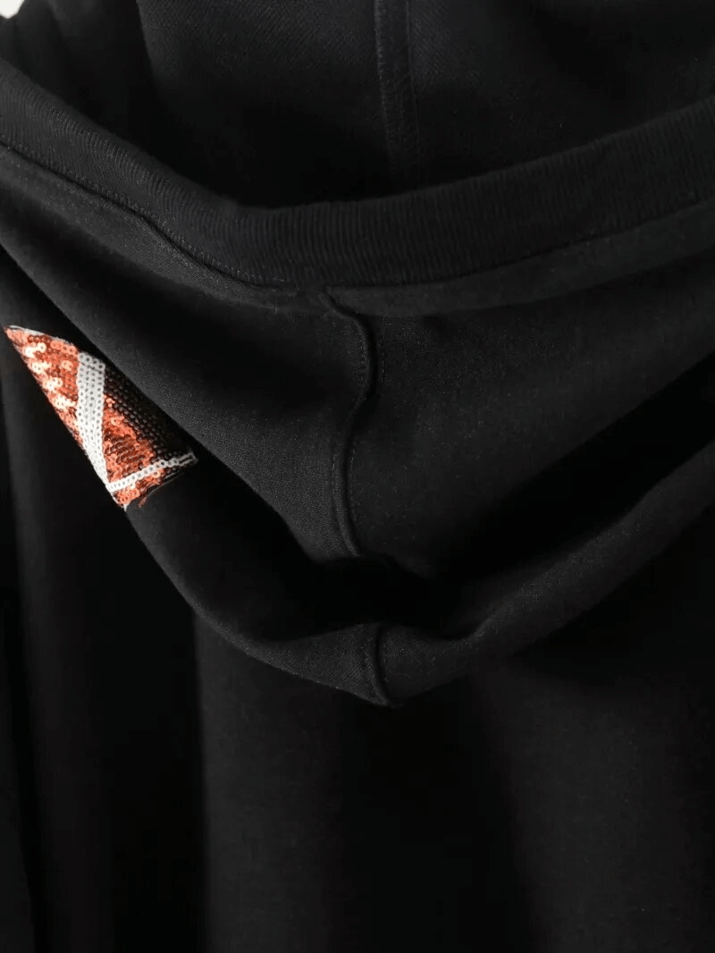 Close-up of black hoodie with hood, featuring sequin detail on edge, made of high-quality cotton for sporty casual wear.