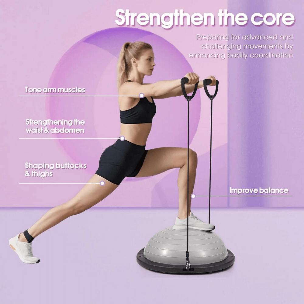 Woman using a Half Balance Ball Trainer with resistance bands for core strengthening and balance exercises in a fitness studio.