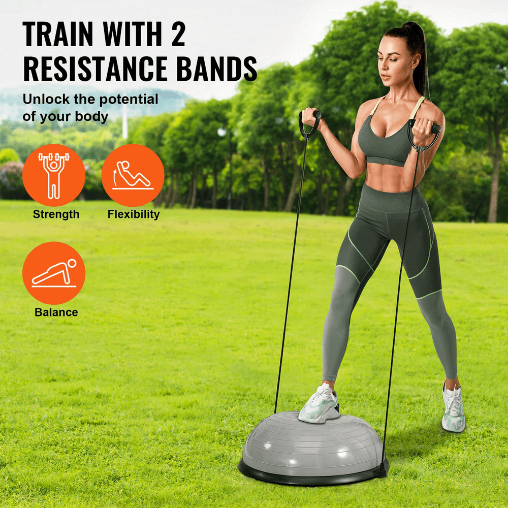 Woman using stability ball with resistance bands for strength and balance training outdoors, promoting flexibility and fitness.