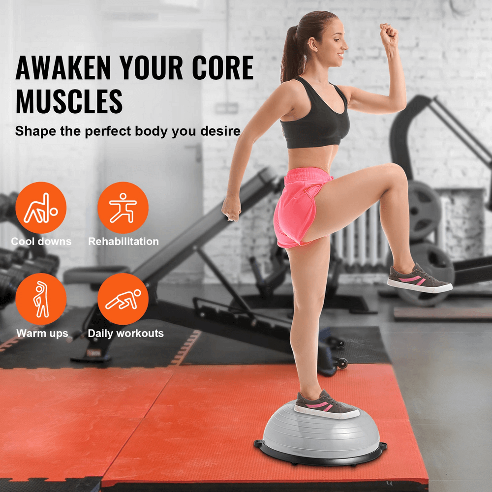 Woman exercising on a half balance ball trainer with resistance bands in a gym setting, focusing on core and stability.