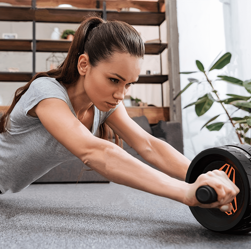 Woman using stainless steel ab roller wheel for core workout at home