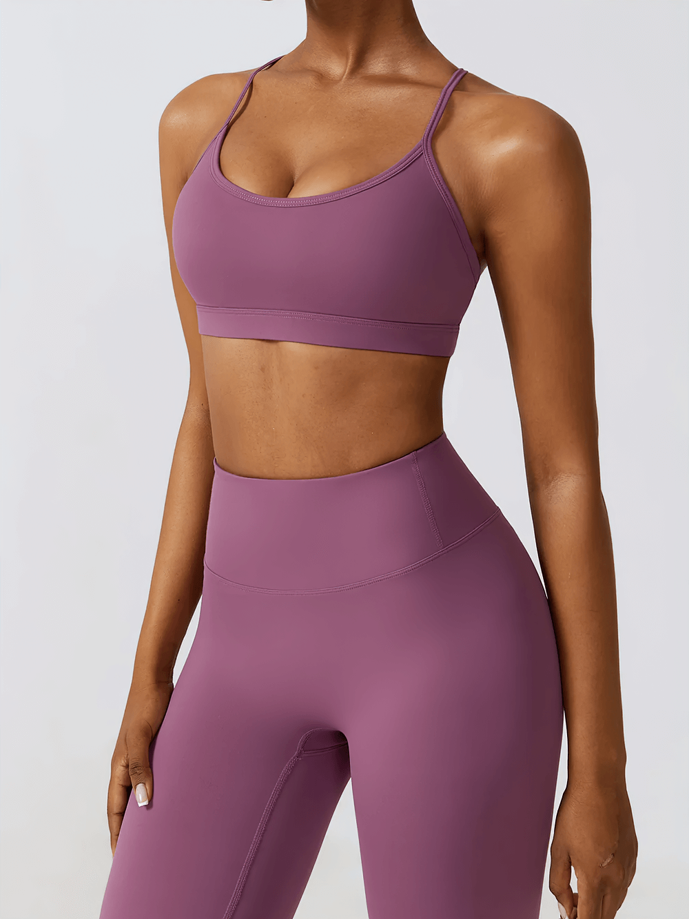 Woman wearing a seamless strappy back sports bra in purple, perfect for workouts, yoga, and casual wear. SF2455 activewear.
