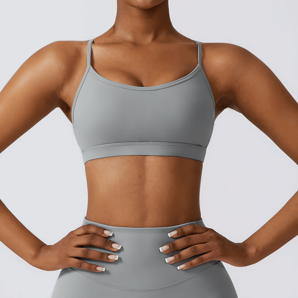 Gray strappy back sports bra featuring a seamless design, perfect for workouts and yoga with moisture-wicking fabric for fitness comfort.