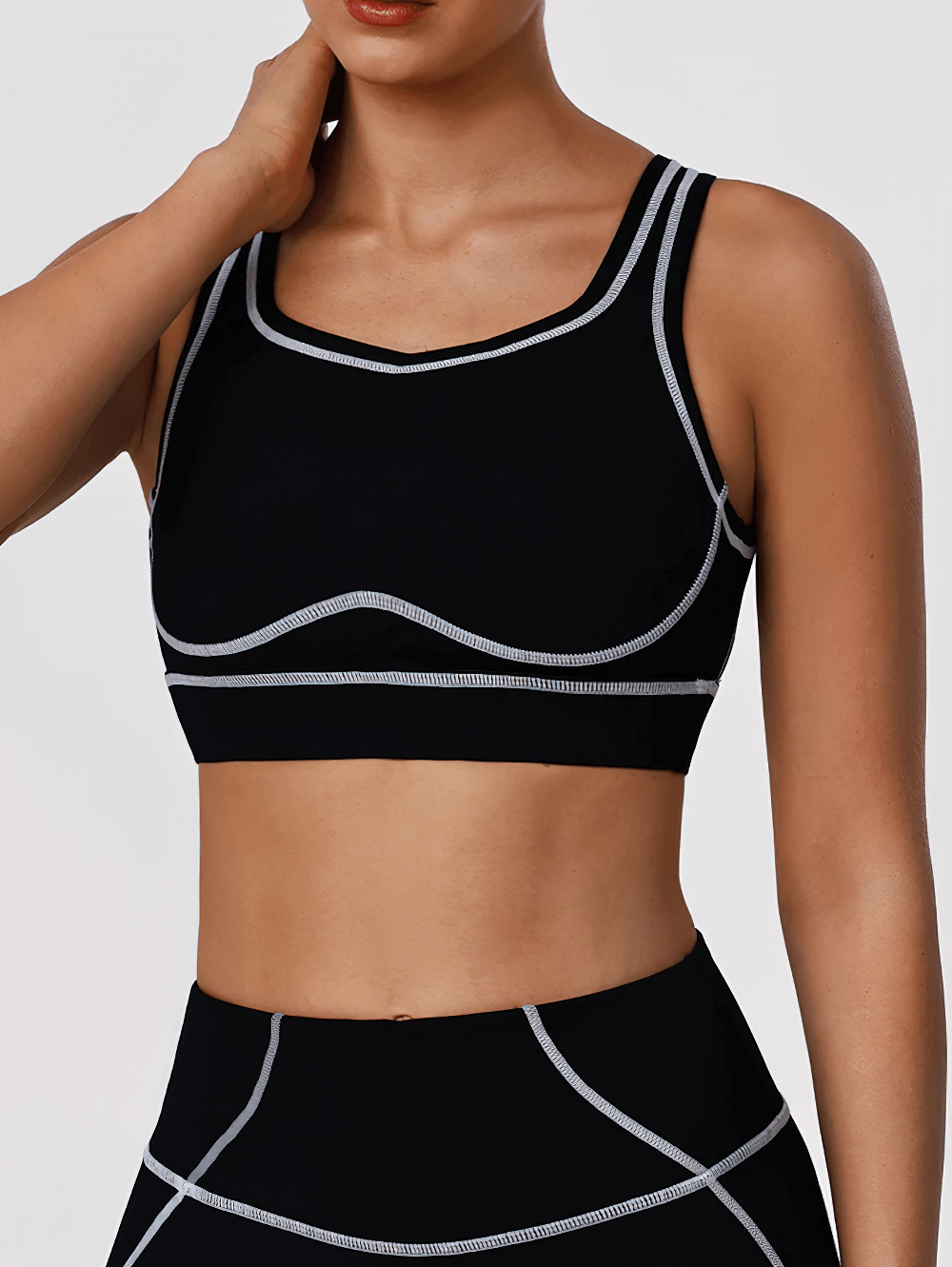 Woman wearing Strappy Back Sports Bra with Removable Pads - SF4062, featuring a square neck, contrast seams, and multi-strap back.
