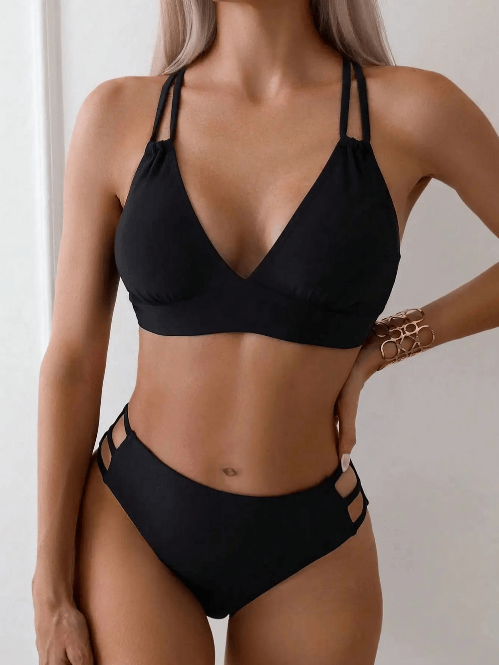 Strappy black bikini set with crisscross design, showcasing modern elegance and flattering fit for beachwear fashion.