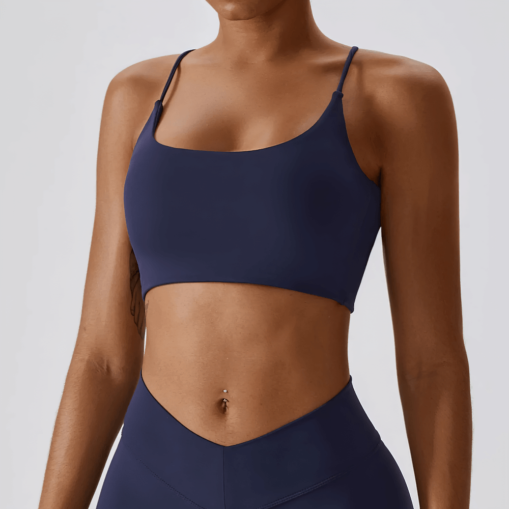 Strappy cross-back sports bra for women in navy, showing sleek design with criss-cross back. Ideal for gym and yoga workouts.