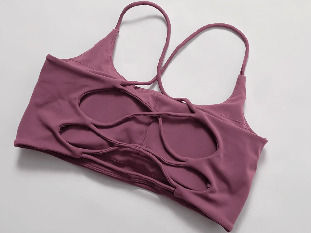 Sleek women's strappy cross-back sports bra in purple, featuring criss-cross back design and moisture-wicking fabric for style and comfort.