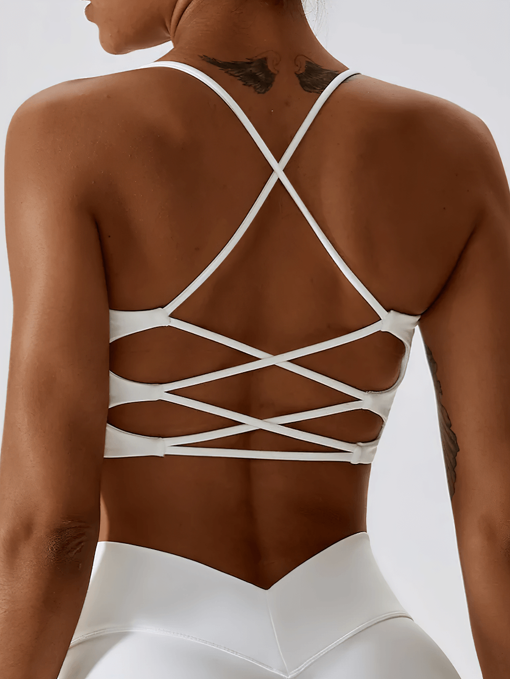 Back view of a sleek women's sports bra featuring a criss-cross design and strappy back, offering light support and style.