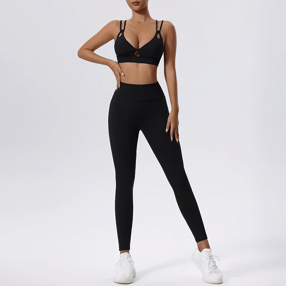 Model wearing strappy sports bra and high-waisted leggings set for yoga, featuring breathable material for enhanced performance.