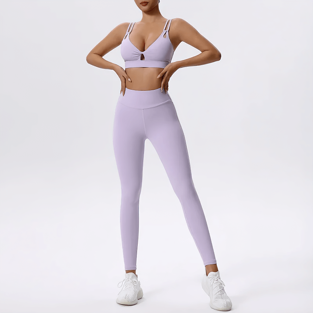 Strappy sports bra and high-waisted leggings set in lilac, perfect for yoga and gym workouts, featuring a stylish crisscross design.