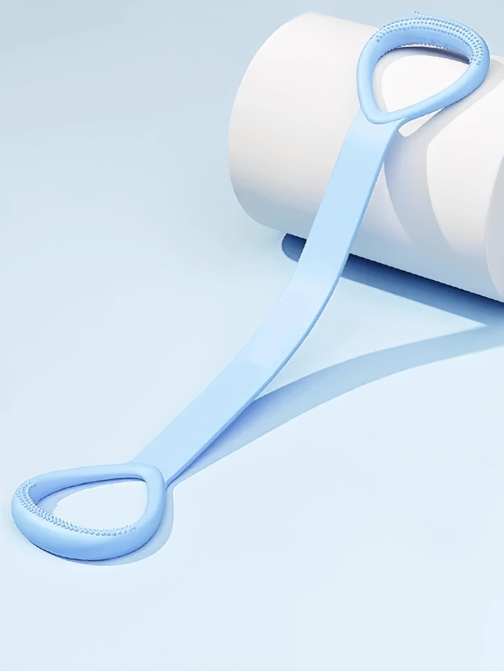 Light blue stretch band with ergonomic handles for yoga and strength training, resting on a white yoga mat roller.