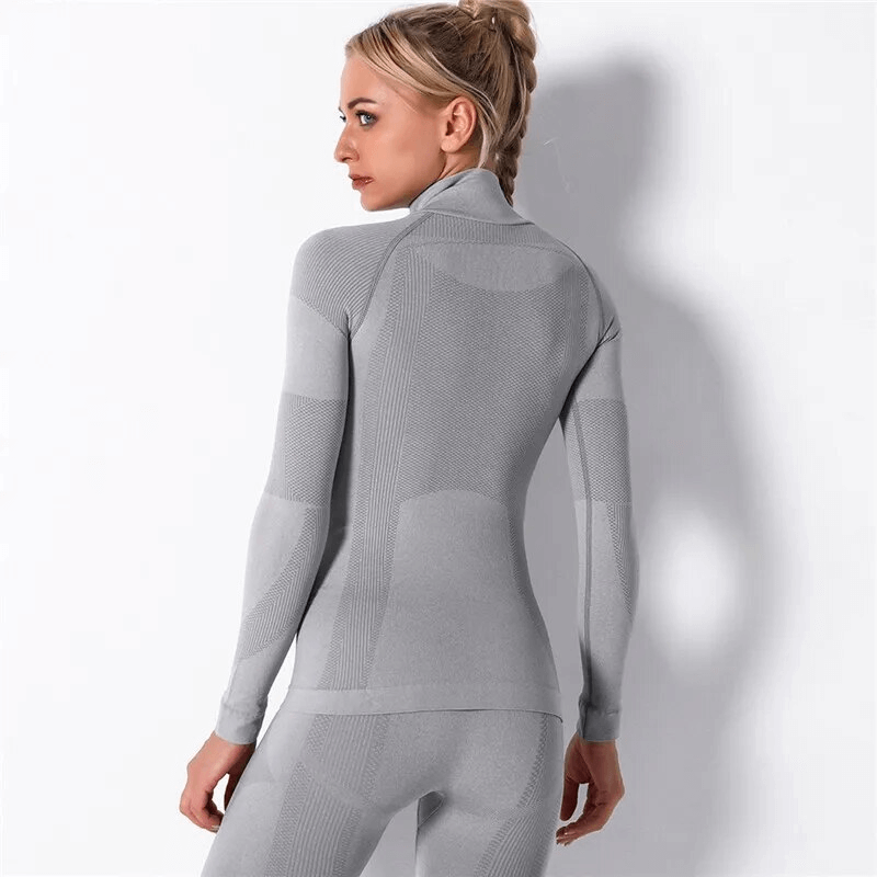 Female model wearing a seamless stretchy long sleeve sports top in gray, ideal for yoga and exercise, crafted from soft nylon fabric.