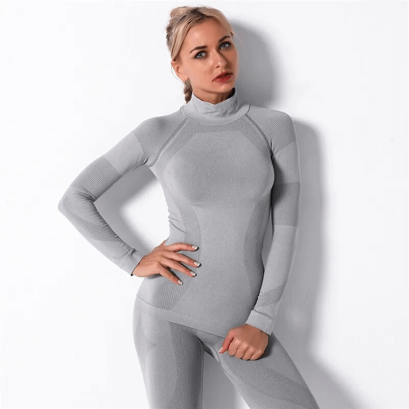 Woman wearing a gray seamless long sleeves top for sport, made with stretchy, breathable nylon fabric. Perfect for yoga and workouts.