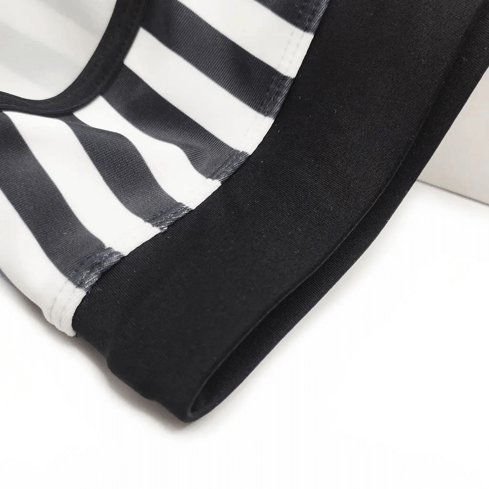 Close-up of zebra print quick-dry men's swim briefs, highlighting black and white stripes with comfortable fabric detail.