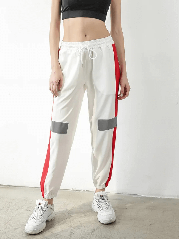 Chic athletic joggers with red and grey patchwork, elastic waistband, ideal for modern active wear.