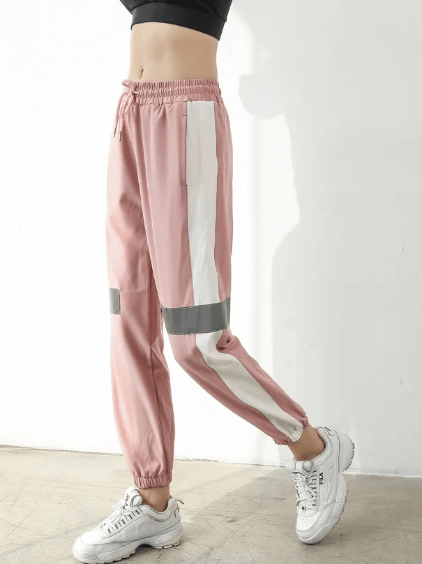 Stylish pink patchwork joggers with elastic waist, featuring white and gray contrast stripes, perfect for active wear and modern style.