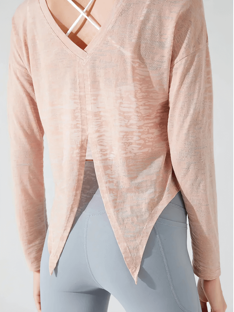 Back view of a stylish back-cutout see-through top, perfect for active wear. Trendy long-sleeved loose fit, ideal for workouts.