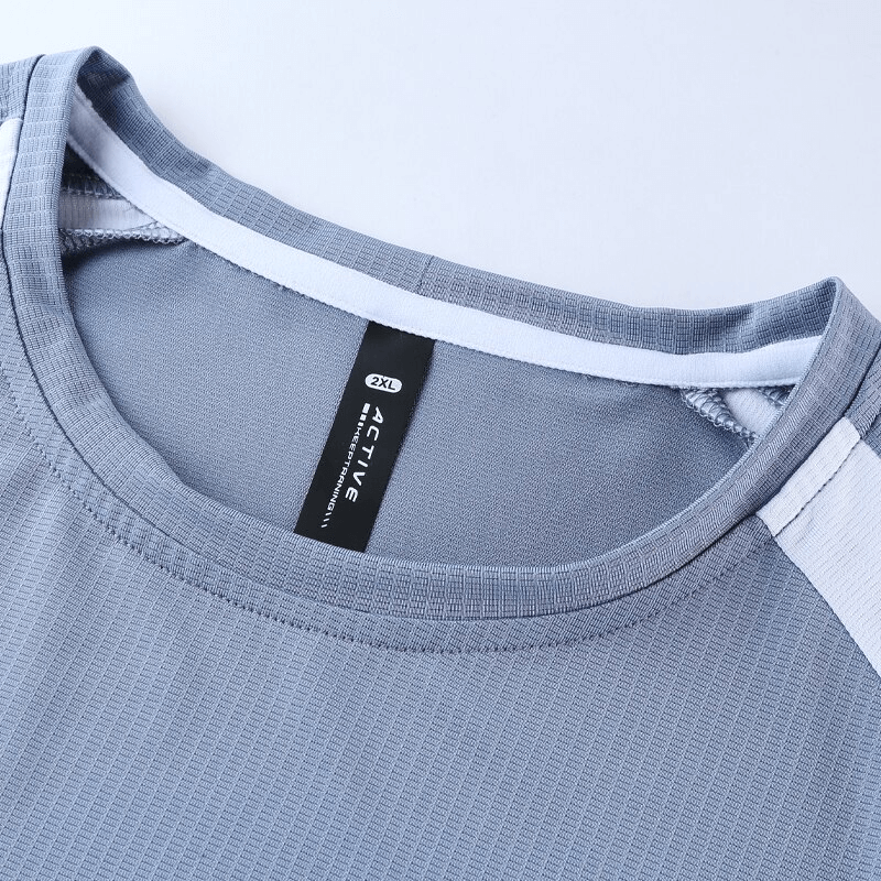 Close-up of stylish breathable quick-drying men's training T-shirt in grey with label and stitching details.