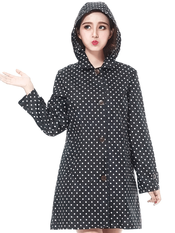Woman in a stylish dot raincoat, waterproof hooded jacket SF1978, modeling raingear with a playful pose.