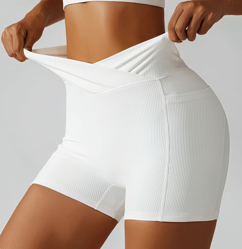 Stylish elastic women's shorts with side pockets, featuring a ribbed design in white, perfect for yoga or casual activities.