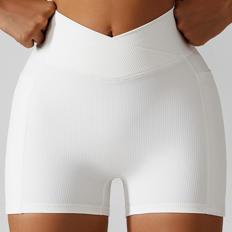 Woman wearing stylish white elastic short women's shorts with side pockets, perfect for yoga and activewear. Product code: SF1336.