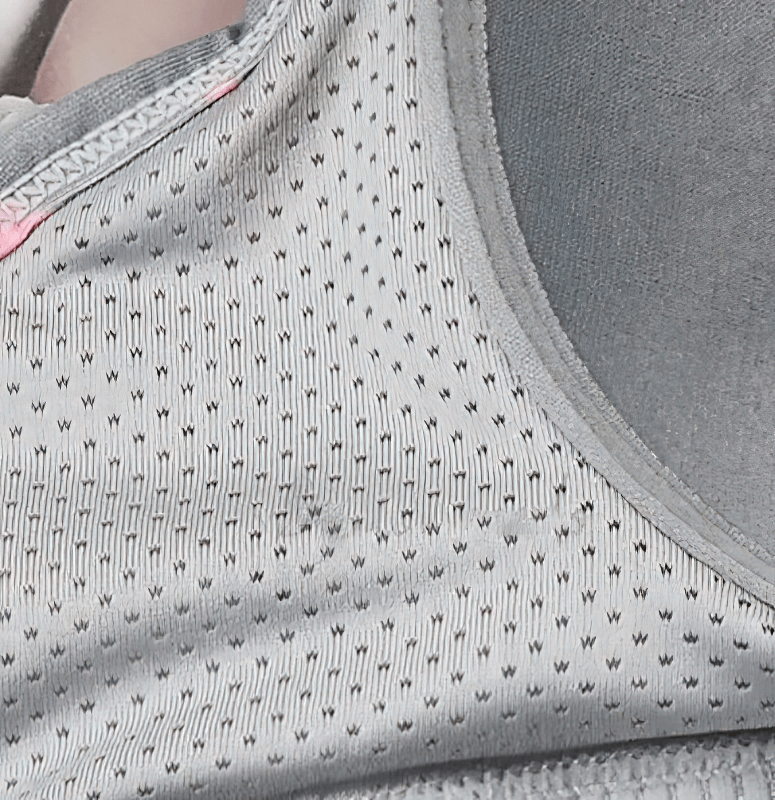 Close-up of a stylish elastic sports bra with breathable fabric and cross back design for women, model SF1610.