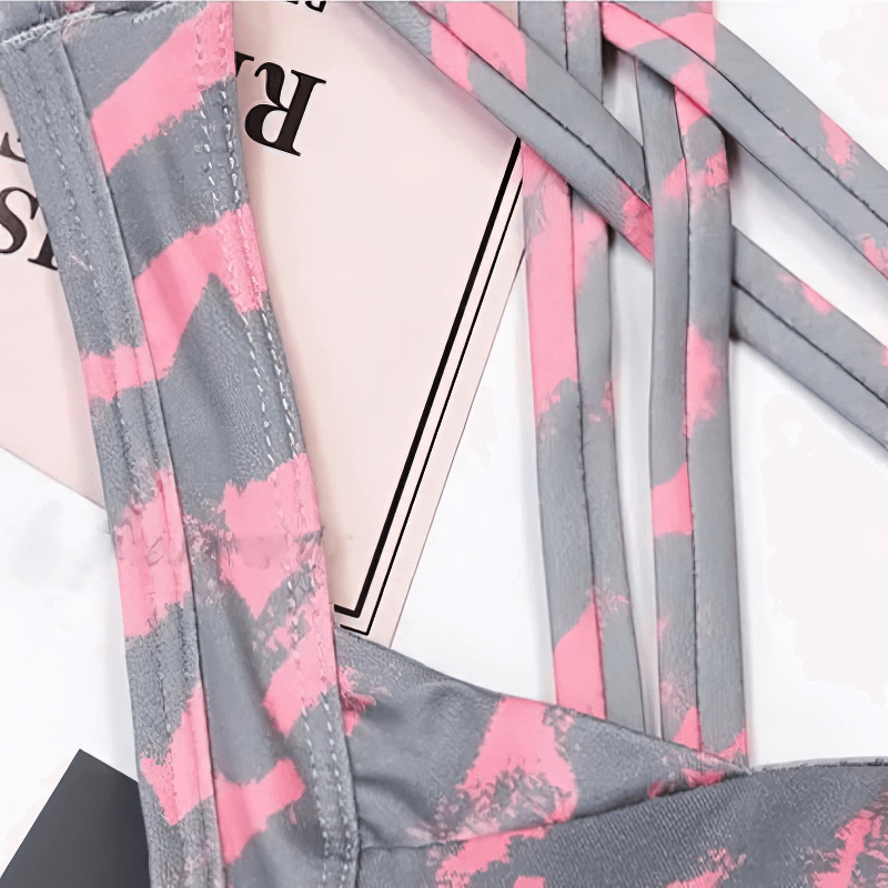 Close-up of pink and grey patterned cross back straps on a stylish elastic sports bra for women.