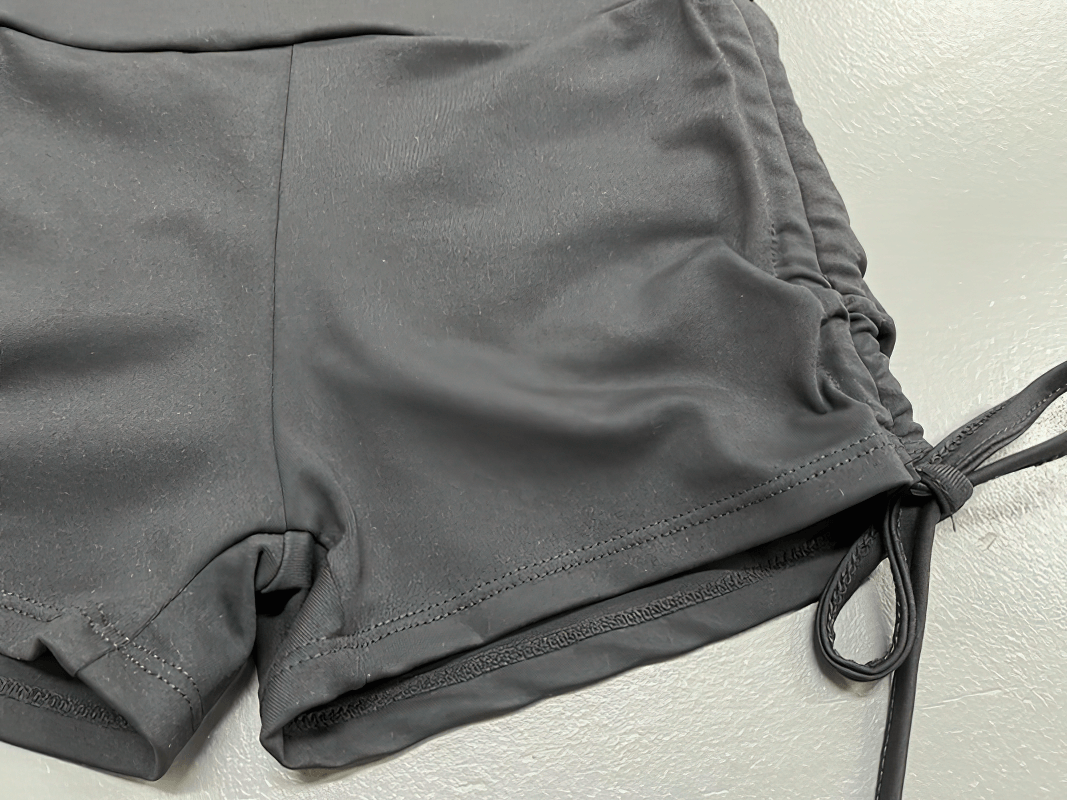 Close-up of stylish elastic sports women's shorts with high waist and back pockets in gray, ideal for yoga, running, and fitness sessions.