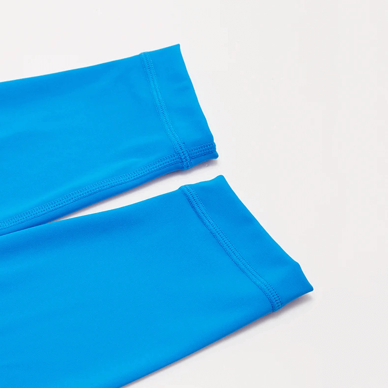 Close-up of bright blue high-waist yoga leggings showcasing elastic waistband and durable knitted fabric. Perfect for workouts.