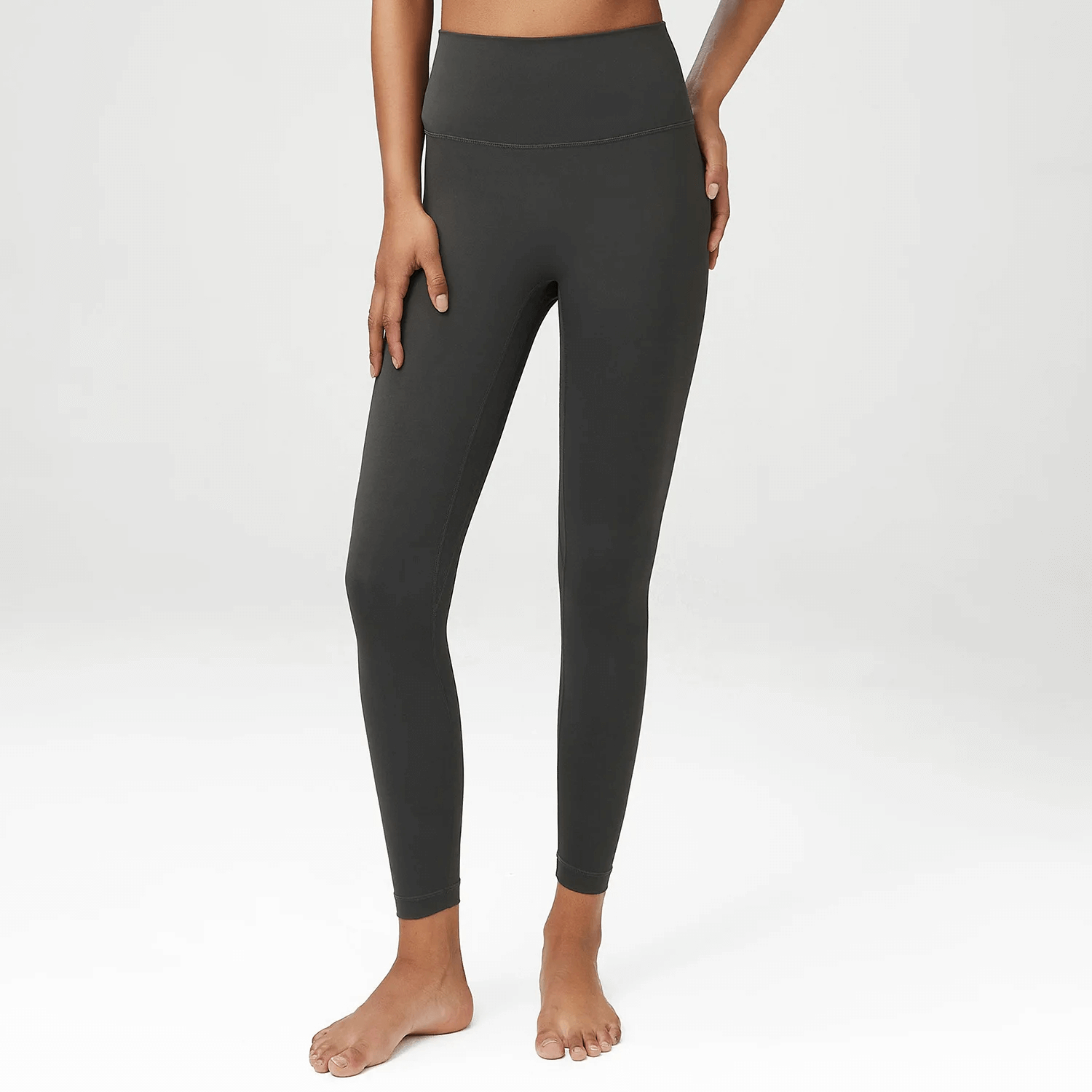 Model wearing stylish black high-waist yoga leggings, crafted from LYCRA for flexibility and comfort, ideal for gym or casual wear.