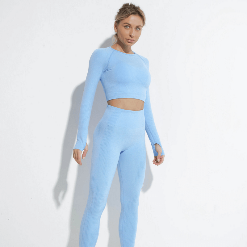 Woman wearing a light blue stylish elastic suit with top and leggings, perfect for yoga and workouts. Solid pattern, nylon material.