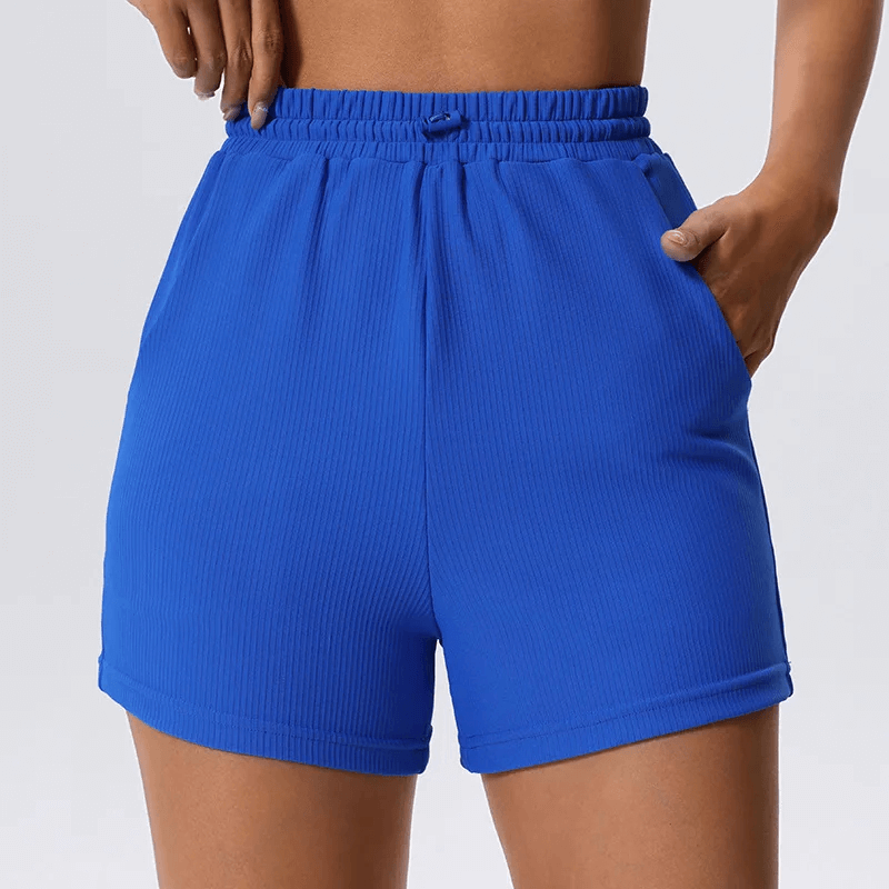 Stylish elegant women's ribbed blue yoga shorts with pockets for active lifestyle; perfect for running, cycling, and dancing.