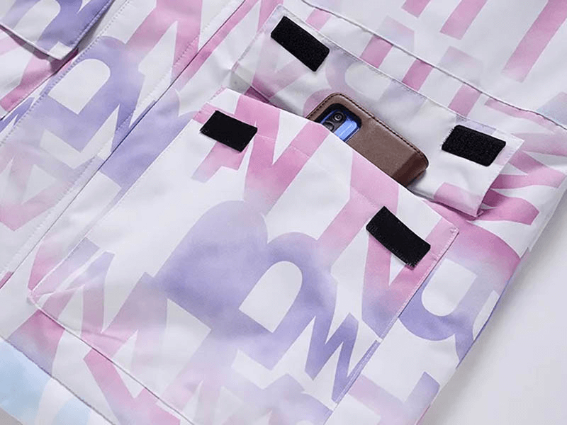 Close-up of letter printed ski jacket with phone in pocket, showcasing stylish design and functionality for female skiers.
