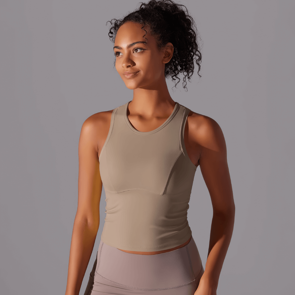 Stylish high-impact sports tank top for women, perfect for yoga and fitness, showcased by a smiling model.