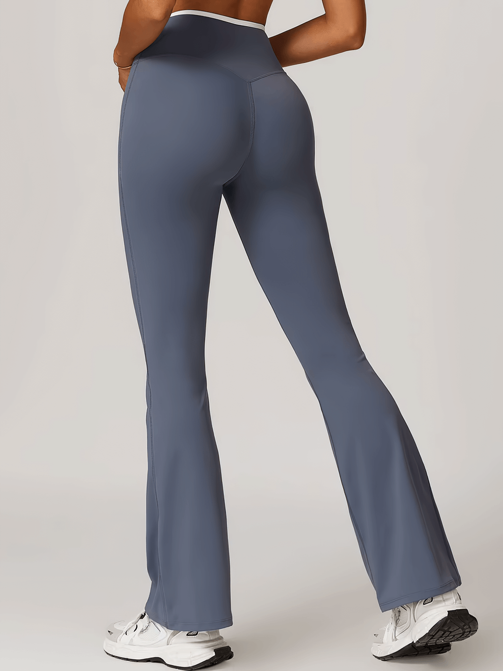 Model wearing stylish high-waist flared yoga pants in blue, showcasing chic elastic bell-bottoms perfect for activewear.