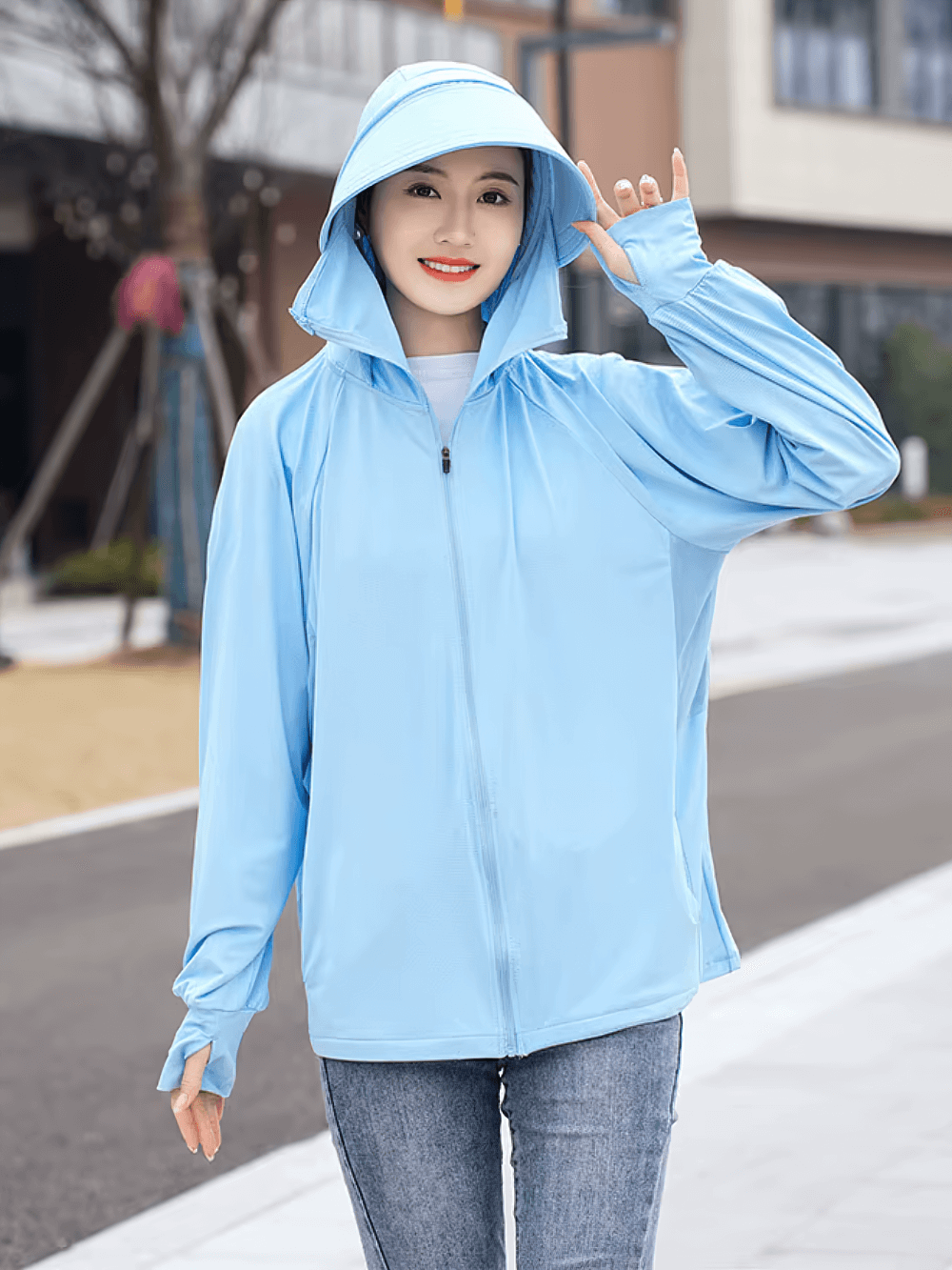 Woman wearing Stylish Hooded UV Protection Ice Silk Sun Jacket SF2306 in light blue, perfect for sunny day outdoor activities.