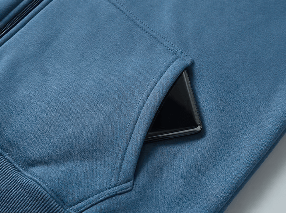 Close-up of blue fleece-lined hoodie pocket with a smartphone, highlighting casual comfort and practicality.