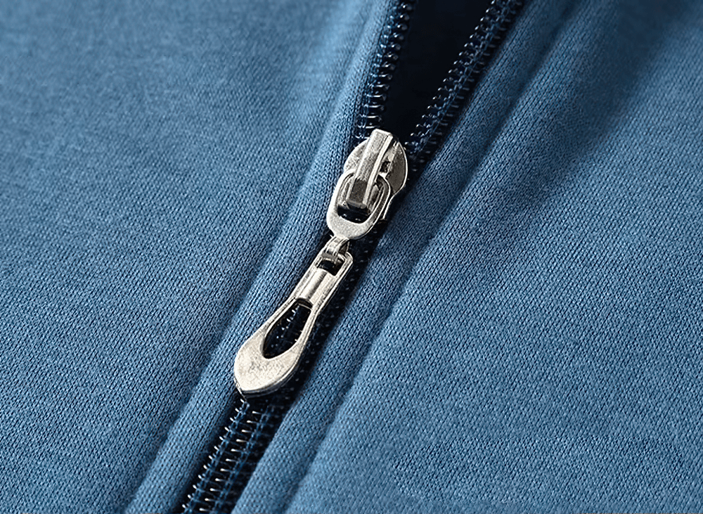 Close-up of a metallic zipper on a blue fleece hoodie, showcasing quality craftsmanship and casual style.