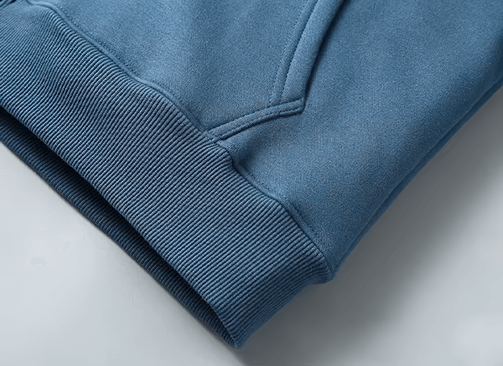 Close-up of a stylish blue casual fleece hoodie hem and pocket detail, highlighting soft fabric and stitching. Ideal for cool weather fashion.