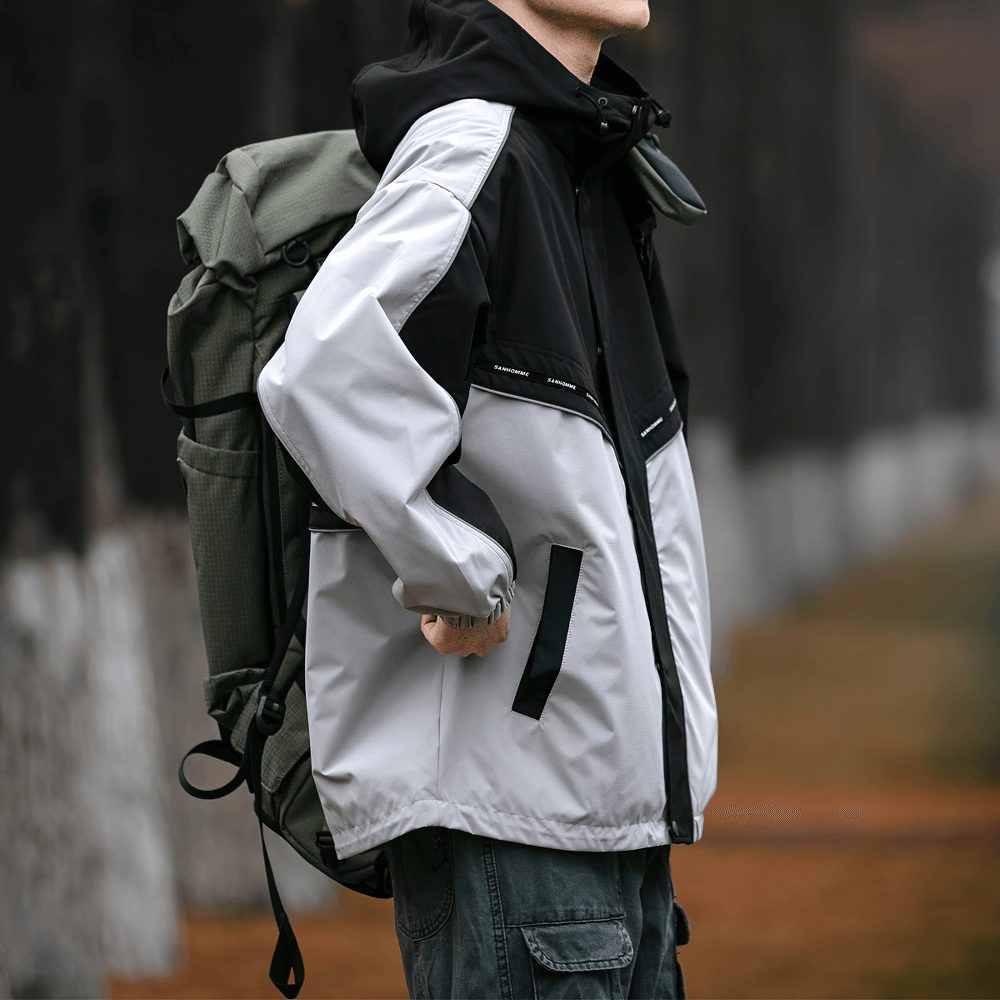 Stylish men's outdoor reflective hooded jacket in white and black patchwork design, perfect for hiking adventures.