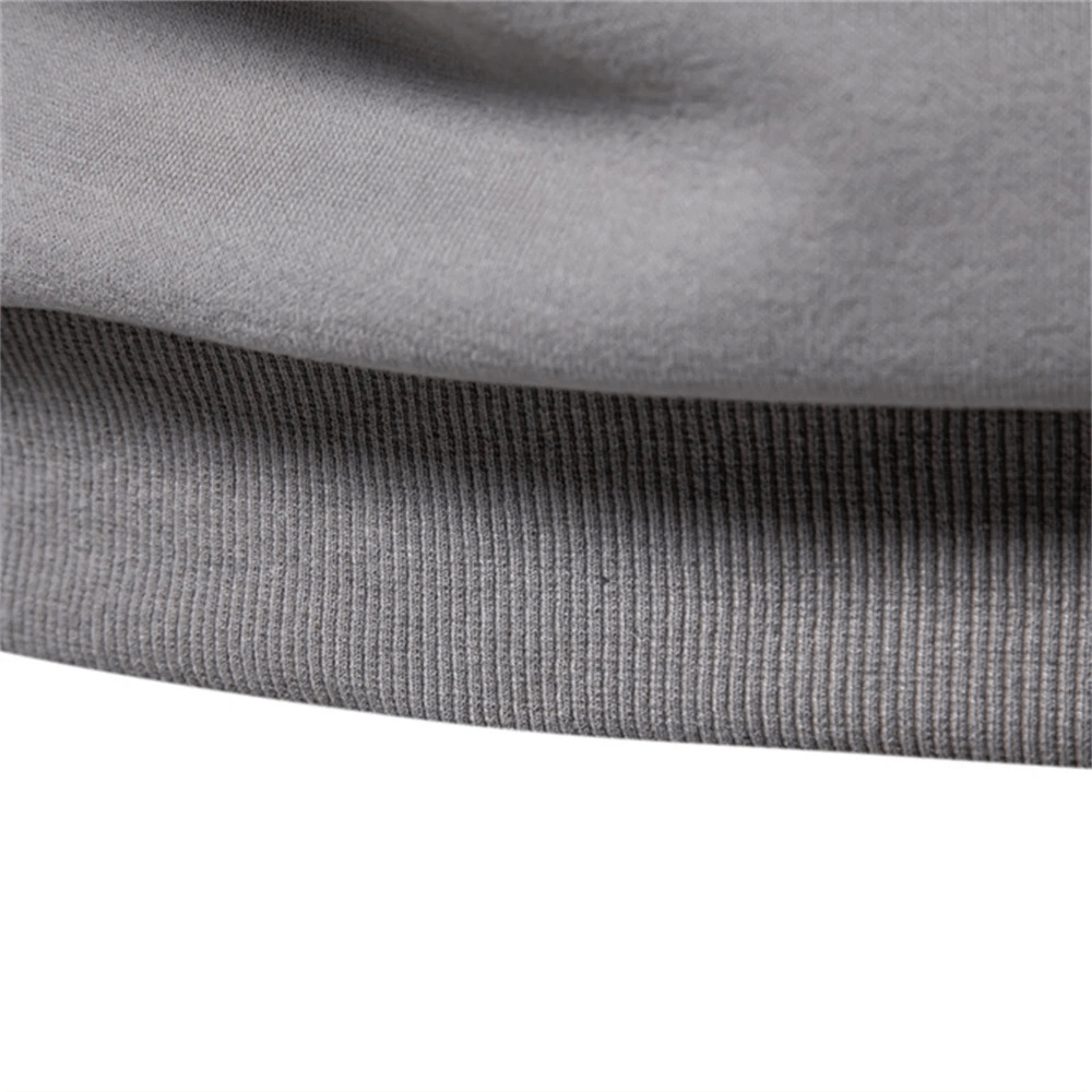 Close-up of stylish men's quarter-zip pullover hem detailing in gray fabric. Ideal lightweight casual sport wear.