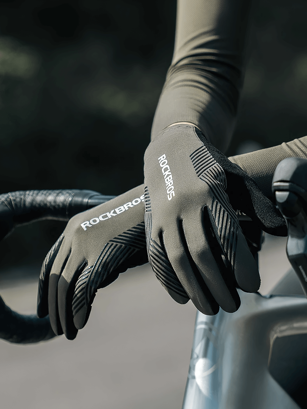 Cyclist wearing stylish non-slip full finger cycling gloves on bike handlebars, ideal for MTB and road biking with touchscreen capability.