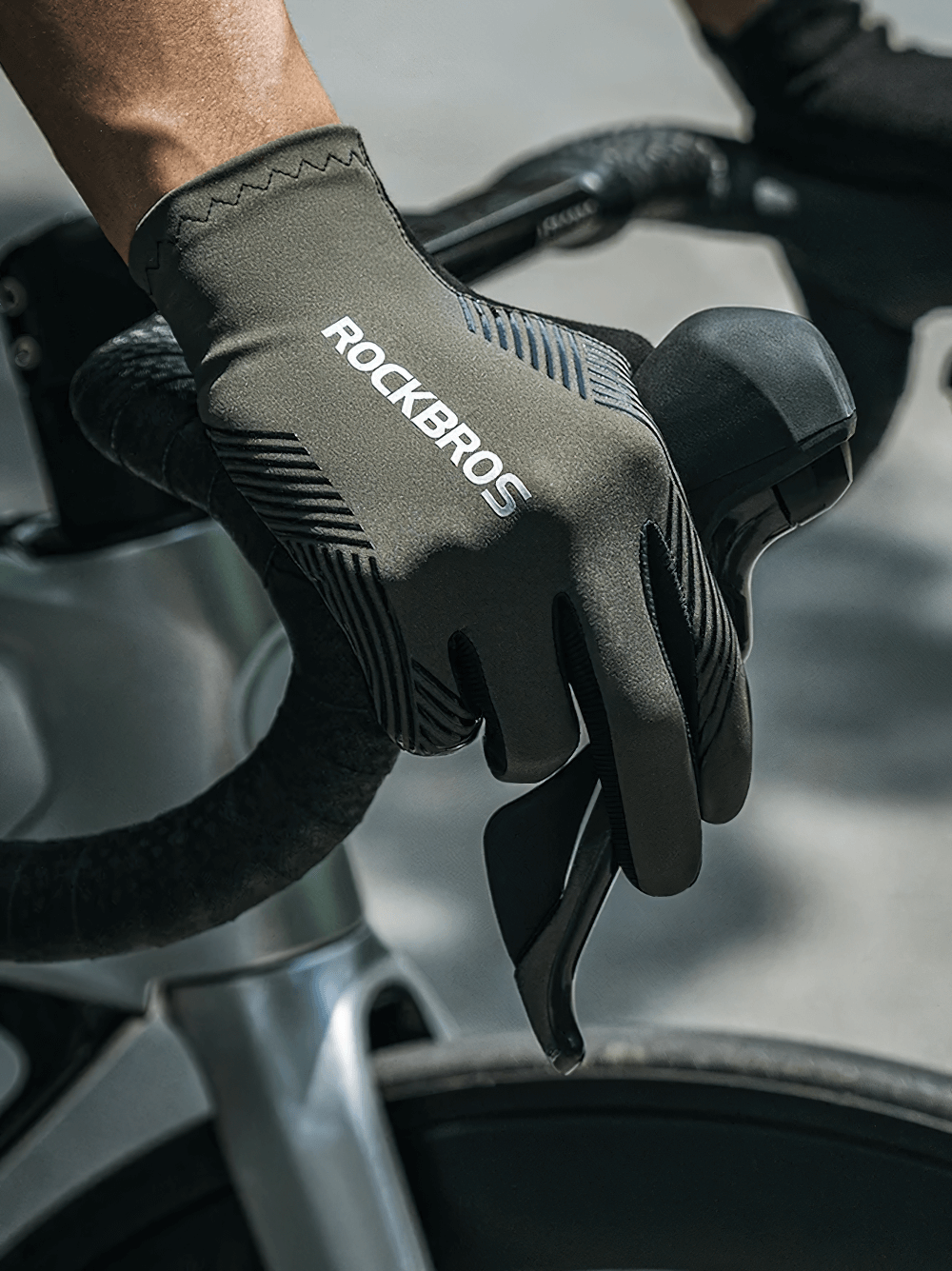 Cyclist wearing Stylish Non-Slip Full Finger Cycling Gloves SF2617 on a road bike handlebar, showcasing touchscreen capability.