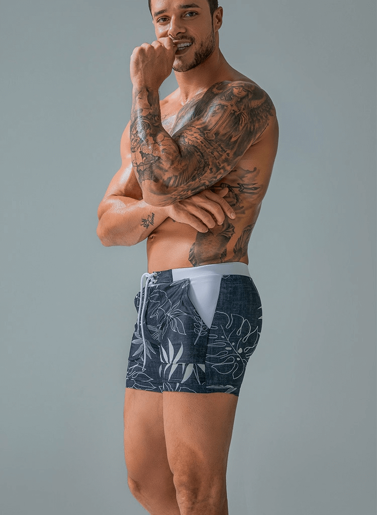 Stylish quick dry men's swim shorts with tropical print and pockets, showcasing breathable and water-repellent polyester fabric.